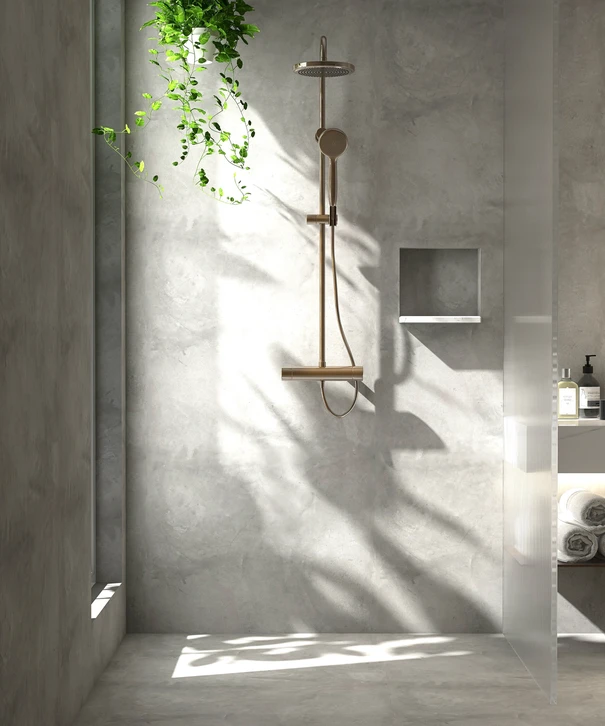 Plombier en combinaison bleue intervenant dans salle de bain moderne, installant ou réparant toilettes WC